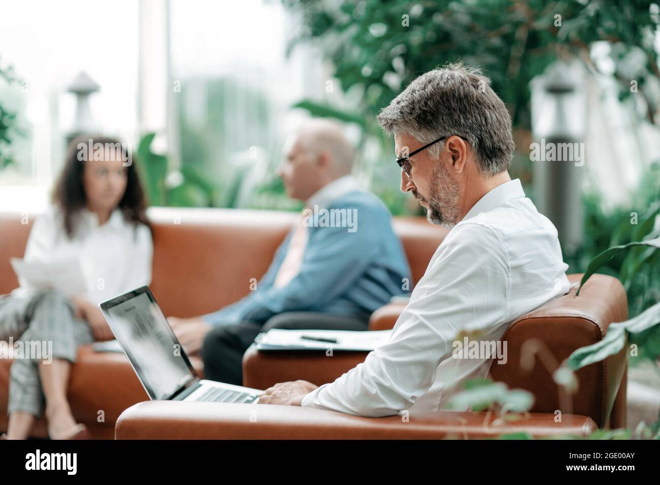 uomo d'affari lavora su un portatile con dati finanziari. Foto Stock