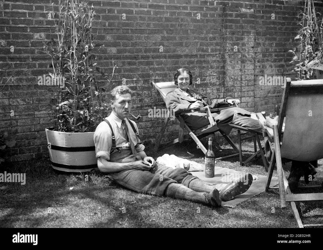 Coppia famiglia relax in giardino con un bicchiere di Martini in Gran Bretagna UK 1923 Foto Stock