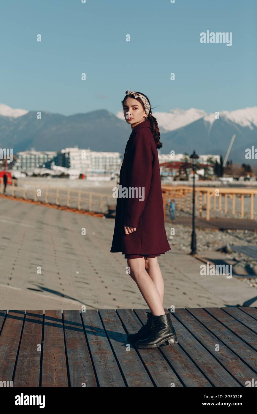 Giovane donna in camice all'aperto su sfondo di montagna. Foto Stock