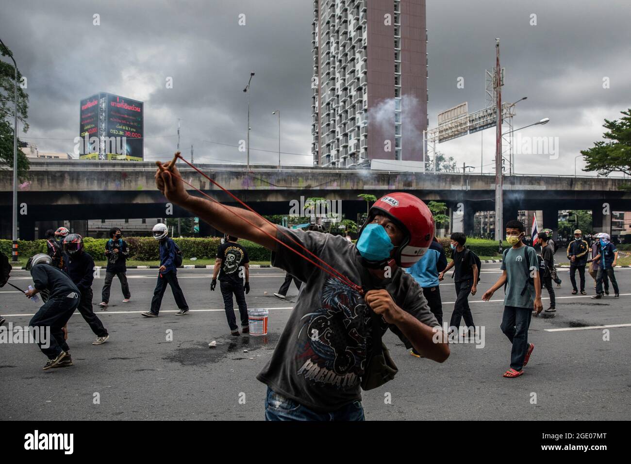 Bangkok, Thailandia. 15 agosto 2021. Un manifestante a favore della democrazia spara un colpo di schiaffo durante gli scontri con la polizia a Bangkok, Thailandia, il 15 agosto 2021. Un rally motociclistico di tutta la città, composto principalmente da Camicie rosse e guidato dall'ex legnista, Nattawut Saikuar, ha attraversato Bangkok in modo pacifico, esortando i manifestanti a non diventare violenti. Tuttavia, alcuni manifestanti, per la maggior parte gruppi giovanili come REDEM, hanno tentato ancora una volta di raggiungere la residenza del primo ministro tailandese, Prayuth Chan-OCHA, che inevitabilmente si è conclusa in scontri con le forze dell'ordine. Credit: ZUMA Press, Inc./Alamy Live News Foto Stock