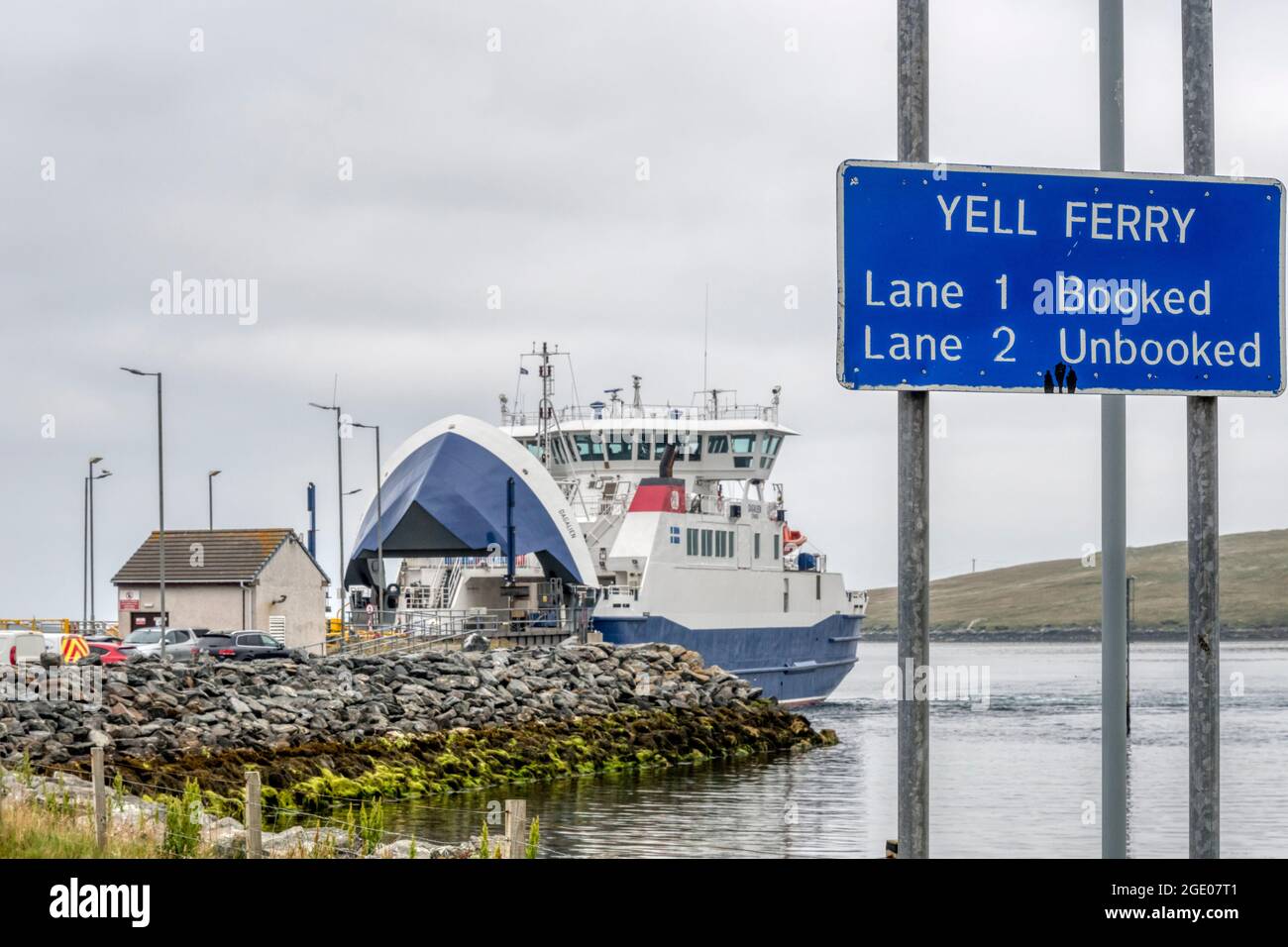 Cartello per il traghetto yell, con il traghetto sullo sfondo, a Toft sulla terraferma Shetland. Foto Stock
