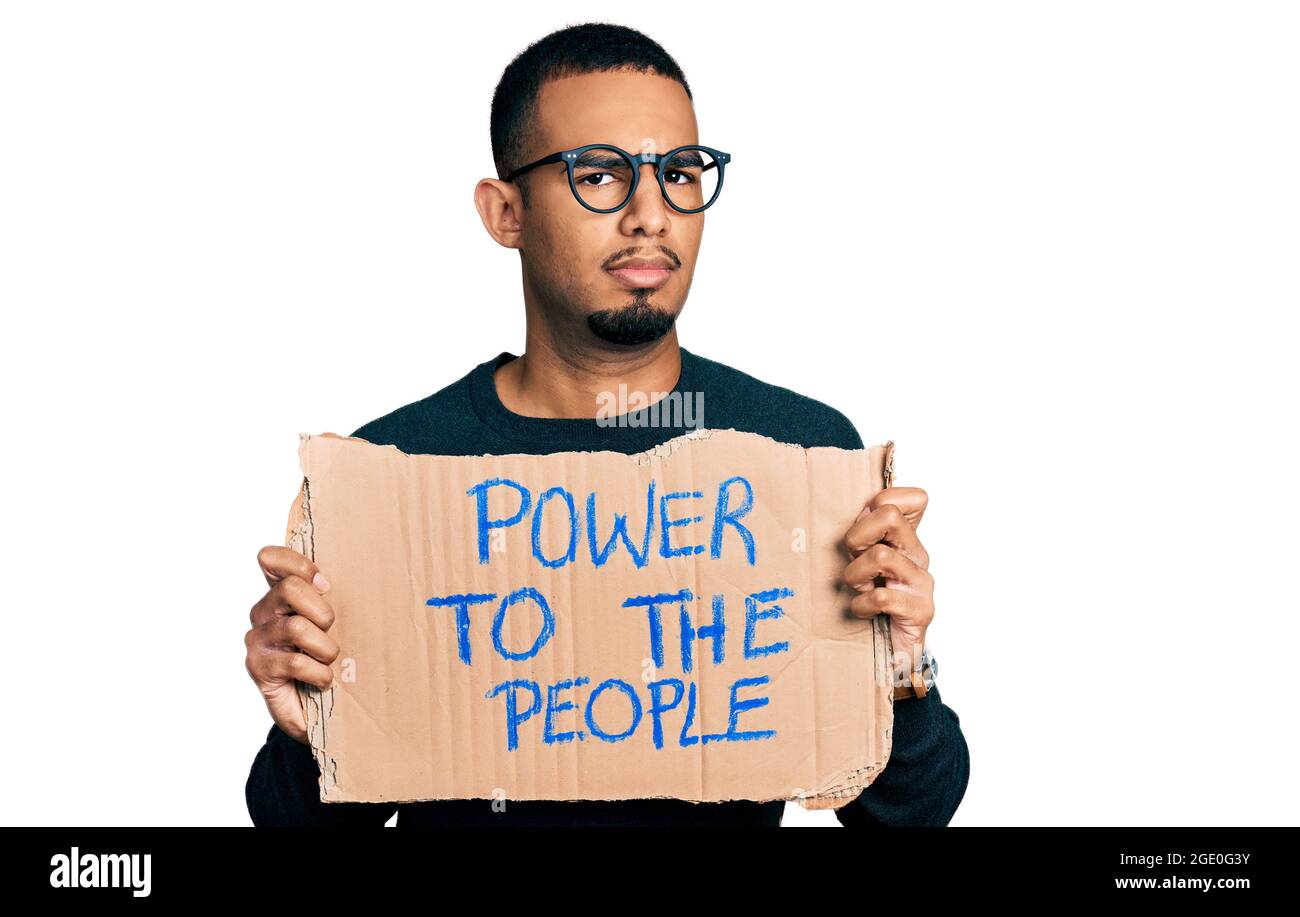 Il giovane afroamericano che detiene il potere al popolo banner indiziato e confuso espressione. Dubbio concetto. Foto Stock