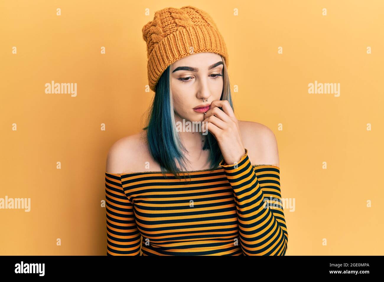 Giovane ragazza moderna che indossa cappello di lana cercando stressato e  nervoso con le mani sulla bocca che mordicchiano i chiodi. Problema di ansia  Foto stock - Alamy