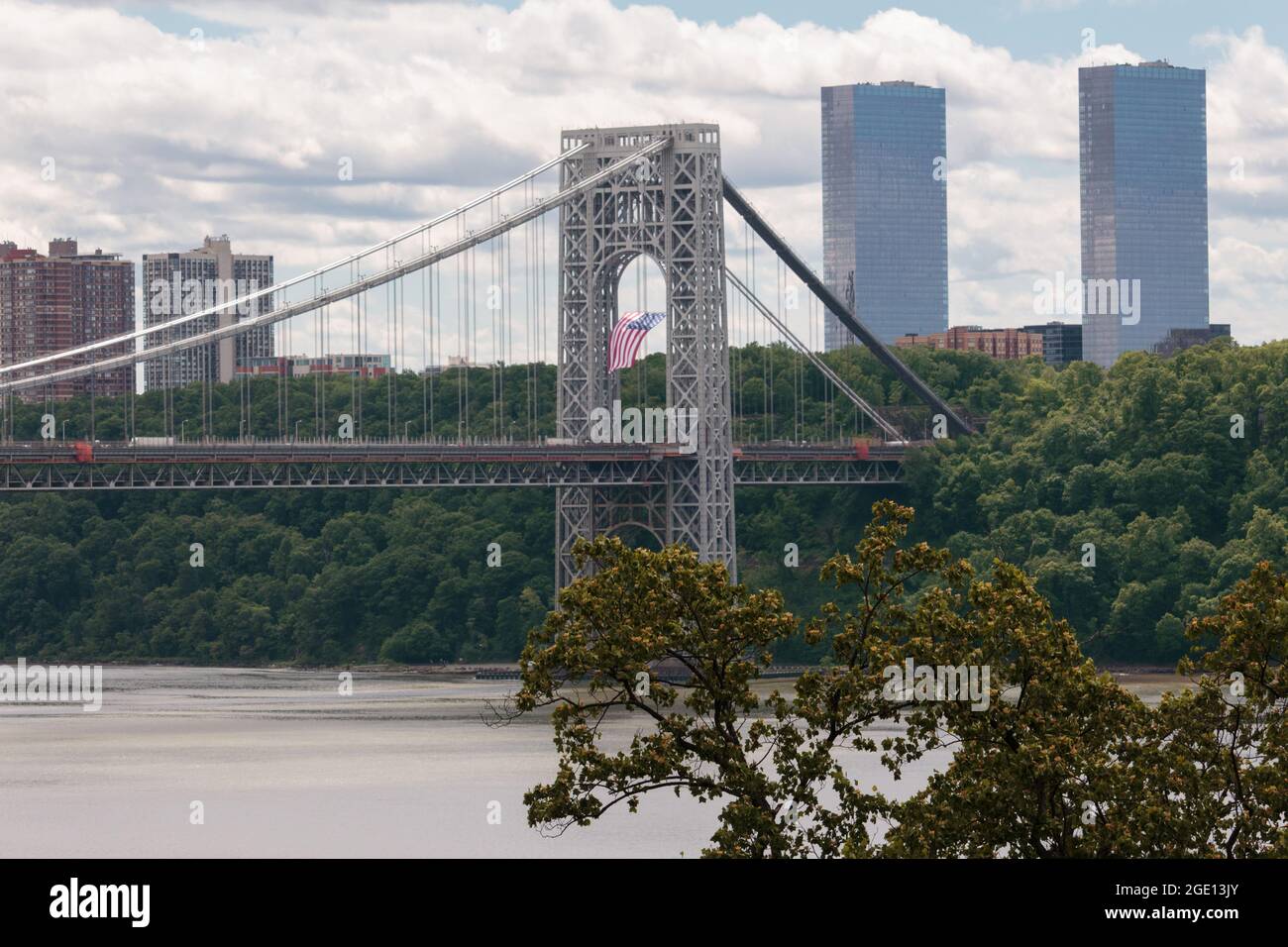 Una bandiera americana pende dalla torre di sospensione laterale del New Jersey del George Washington Bridge, un ponte sospeso a due piani che collega Manhattan Foto Stock