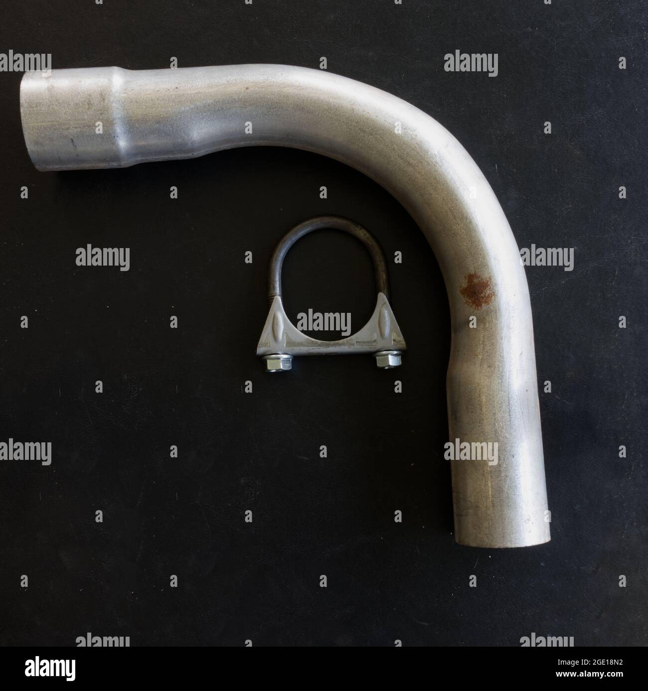 Un tubo di scarico universale e un morsetto su sfondo nero Foto Stock Un tubo di scarico universale e un morsetto su sfondo nero Foto Stock