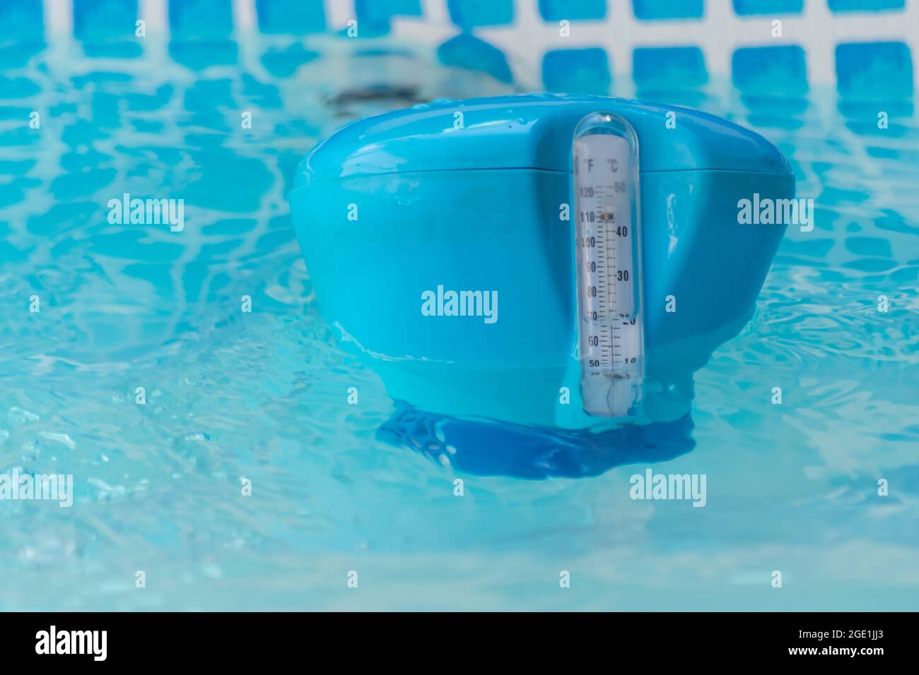 Estate calda, alte temperature, misurazioni della temperatura dell'acqua di piscina con dispositivo galleggiante dell'acqua Foto Stock