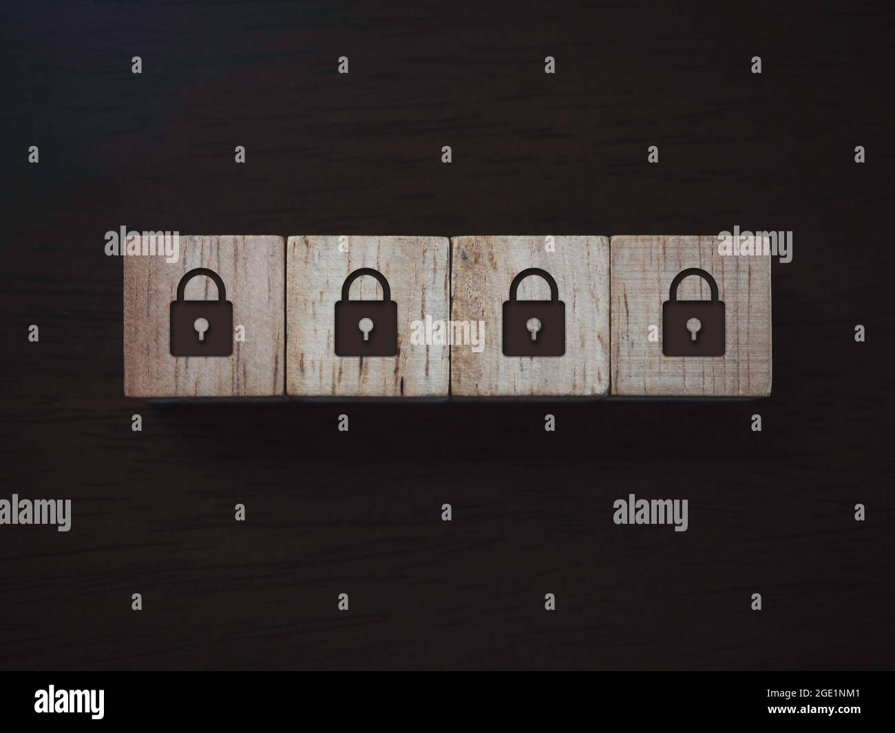 Privacy e protezione dei dati personali. Icona a quattro blocchi su blocchi di legno su sfondo di legno scuro, vista dall'alto. Protezione tramite password. Foto Stock