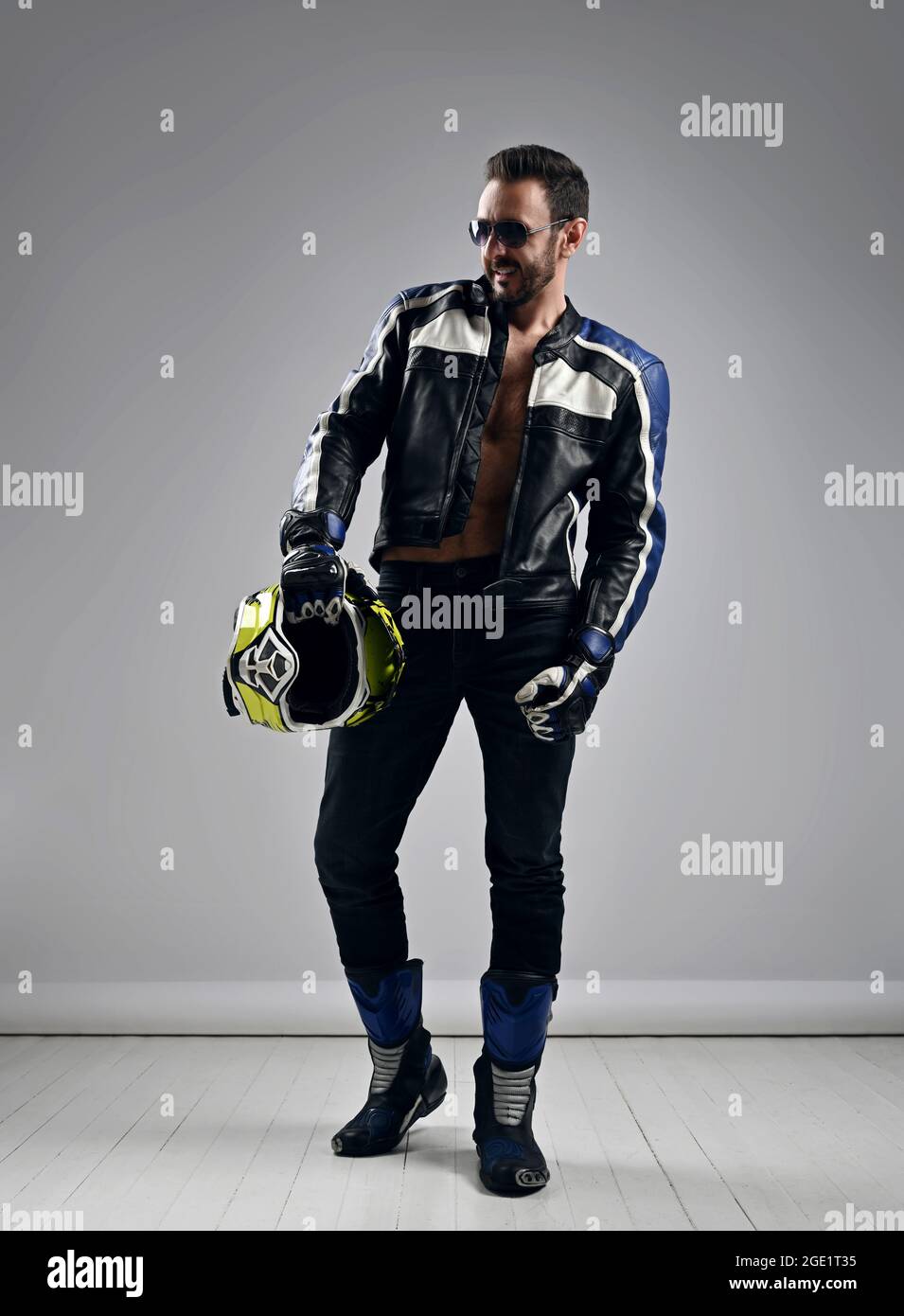 Brutale uomo adulto non rasato motociclista motociclista in stivali da  moto, giacca e guanti cammina con casco in mano Foto stock - Alamy