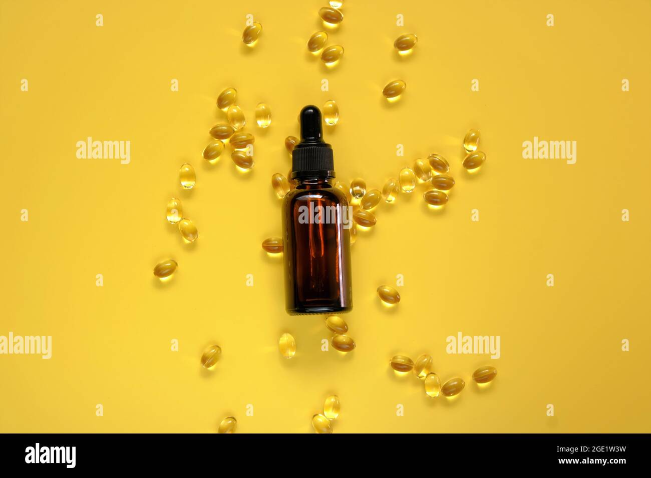 Vitamina D. estratto di olio e gelatina capsule trasparenti con vitamina D su fondo giallo.vitamine e minerali. Integratori alimentari. Foto Stock