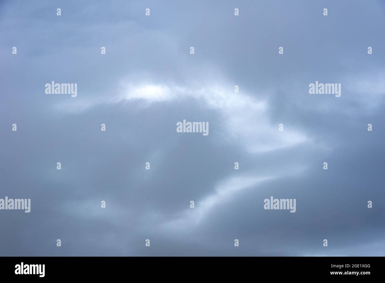 Nuvole blu-grigie nel cielo prima della pioggia. Luce nelle nuvole buie e drammatiche. Perfetto sfondo naturale del cielo, mock-up per il design Foto Stock