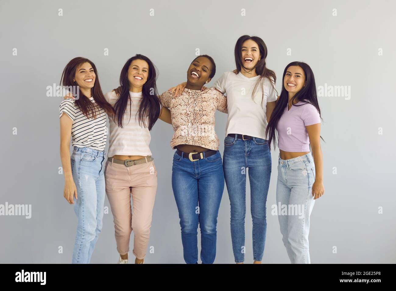 Ritratto di gruppo di allegre e diverse ragazze che saltano e ridono in studio Foto Stock