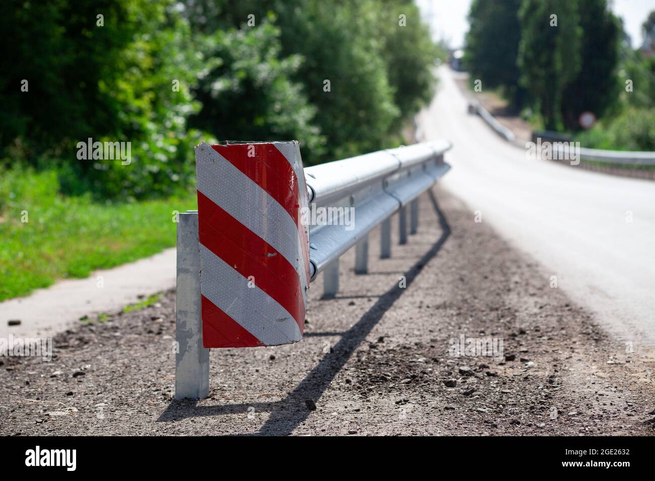 riflettori stradali rossi lungo la strada. recinzioni stradali in metallo di tipo barriera, primo piano. Sicurezza stradale e stradale. Vernice riflettente sul cartello. Barriera mediana Foto Stock