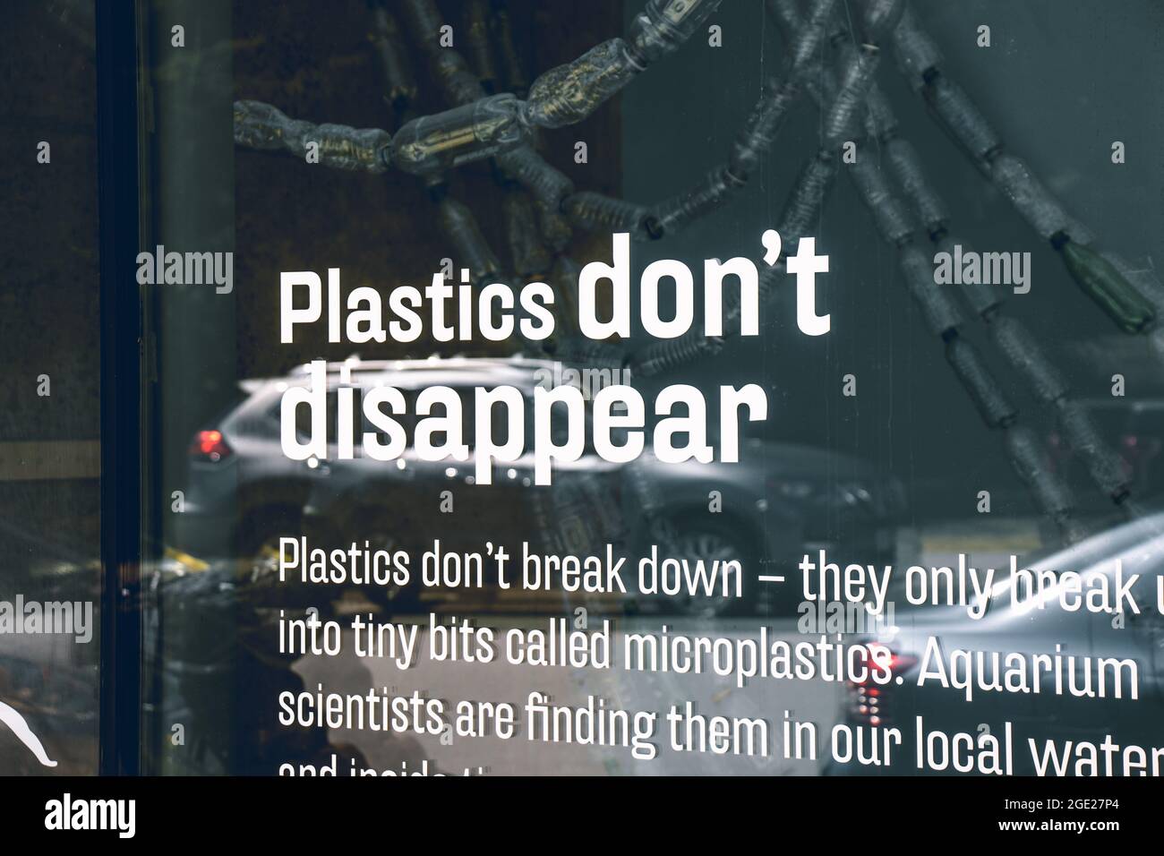 Vista del segno plastica non scompaiono sulla finestra con un sacco di bottiglie di plastica sullo sfondo Foto Stock