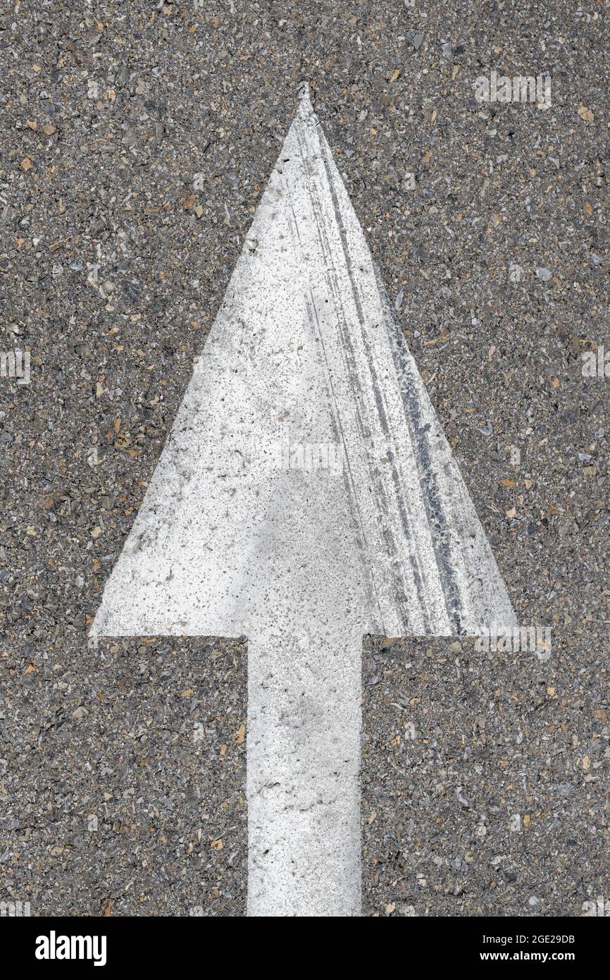 Simbolo della freccia bianca sulla strada asfaltata, indicatore di direzione e guida, vista dall'alto Foto Stock