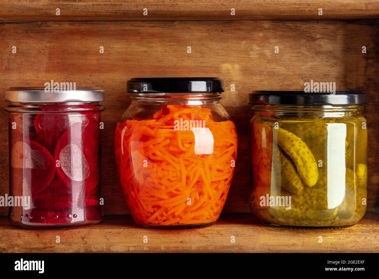 Conserve di dispensa su un ripiano in una cantina di cucina. Carote, barbabietole e cetriolini in vasetti di vetro sottaceto Foto Stock