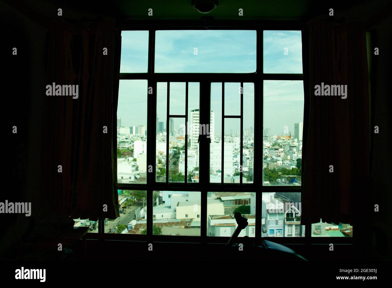 Il vento che passa attraverso tende colorate e griglie in ferro finestra dal cielo blu a ho Chi Minh City, Vietnam. Foto Stock