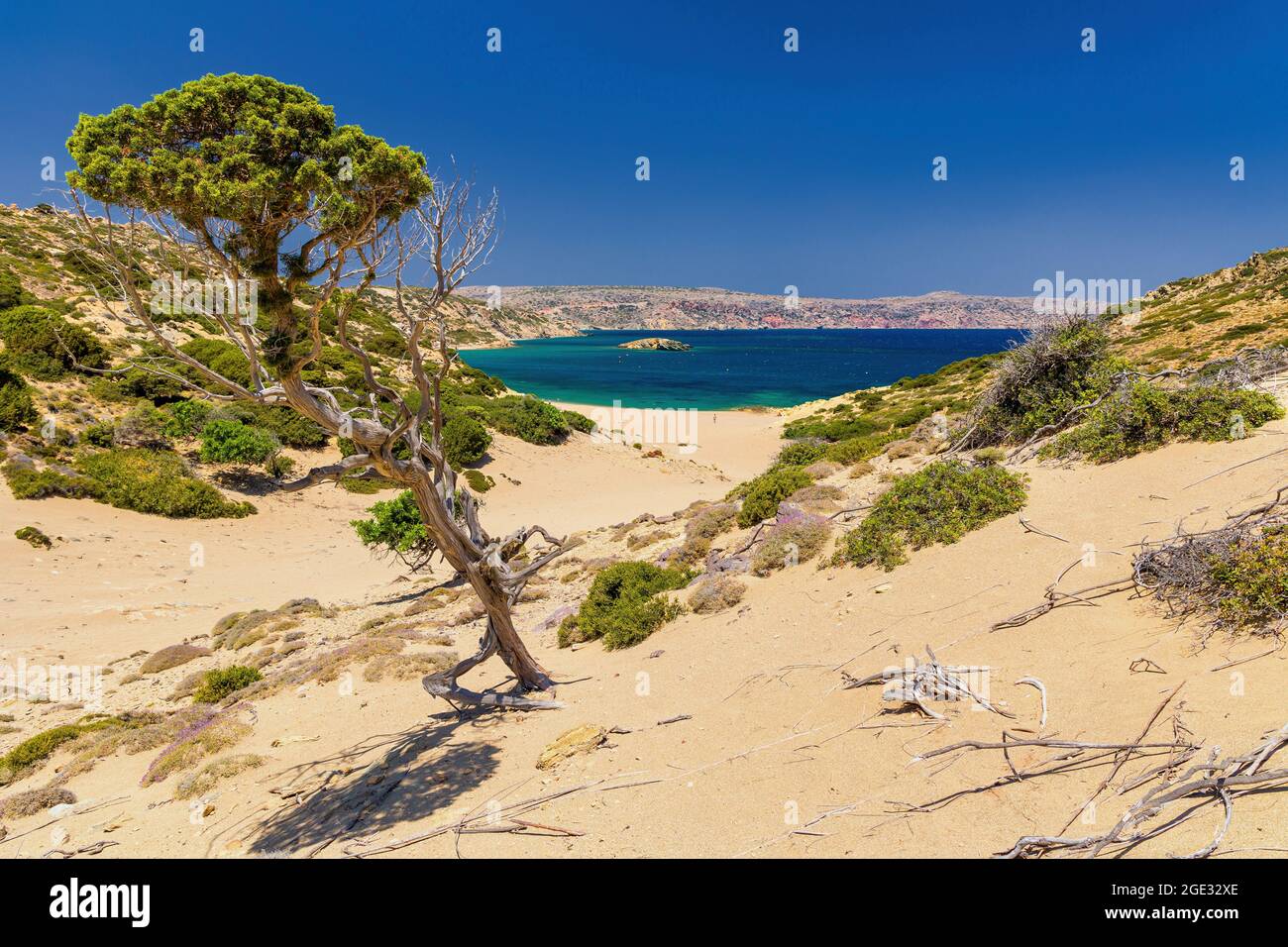 Tranquilla spiaggia di sabbia calda in un paesaggio di macchia che conduce verso un oceano limpido (Psili Ammon, Creta) Foto Stock