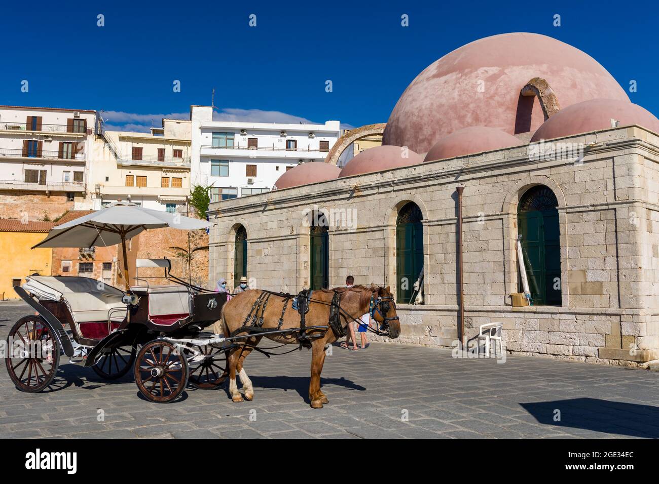 Cavalli e carrozze sul lungomare vicino all'antica moschea di Chania, Creta, Grecia Foto Stock