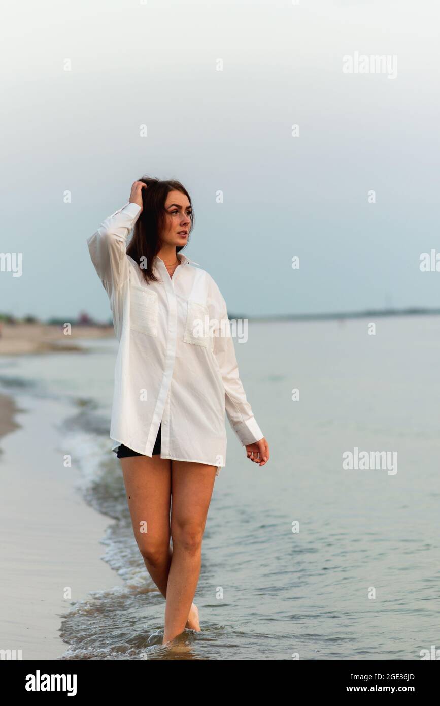 Giovane bella moda ragazza in camicia bianca. Vacanza al mare.Romantic giovane donna su blu naturale sfondo estate all'aperto Foto Stock