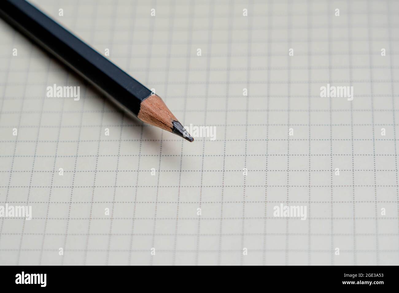 Matita nera e blocco note su sfondo bianco. Foto Stock