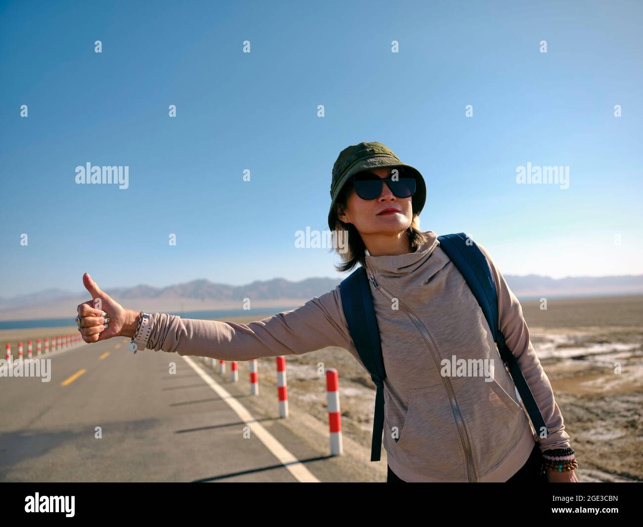 donna asiatica saccopelatore femminile che viaggia da hitchhiking Foto Stock