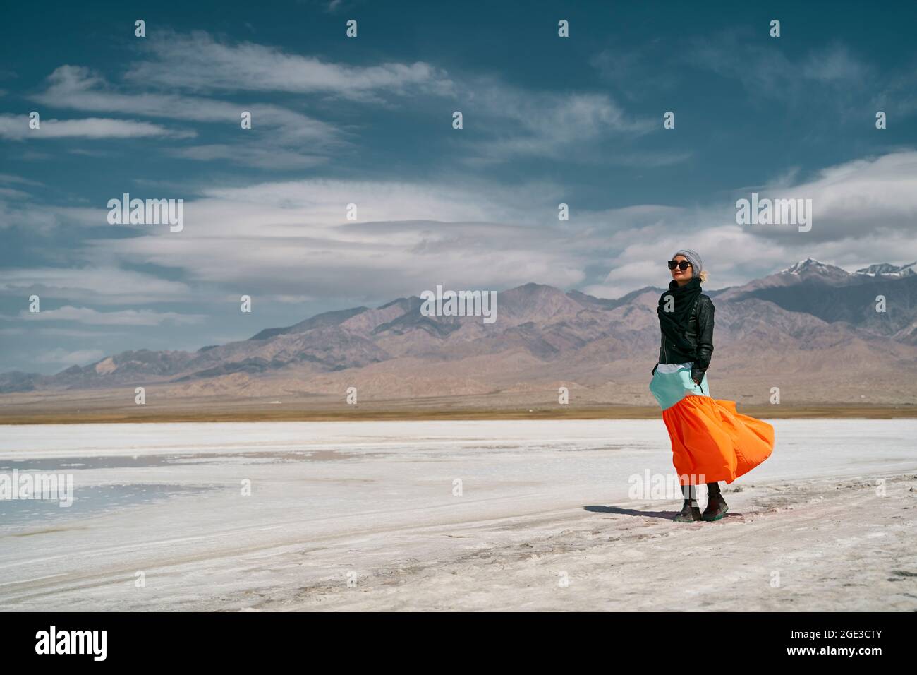 donna asiatica turistica femminile in gonna lunga in piedi su terra salina alcalina Foto Stock
