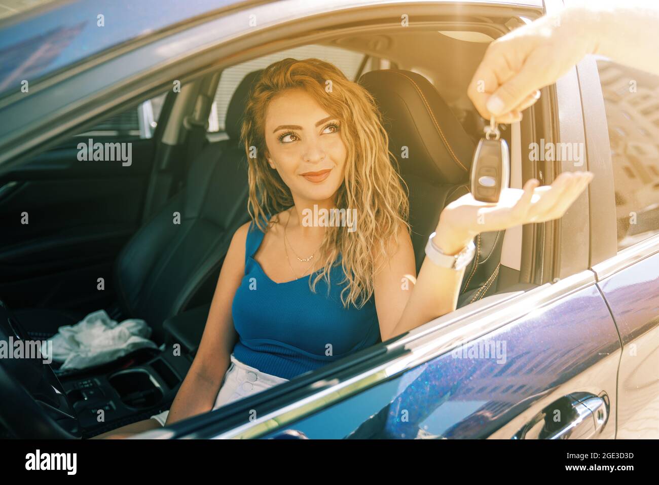 giovane e bella donna prendere la chiave dal cameriere per guidare la sua auto. Foto di alta qualità Foto Stock