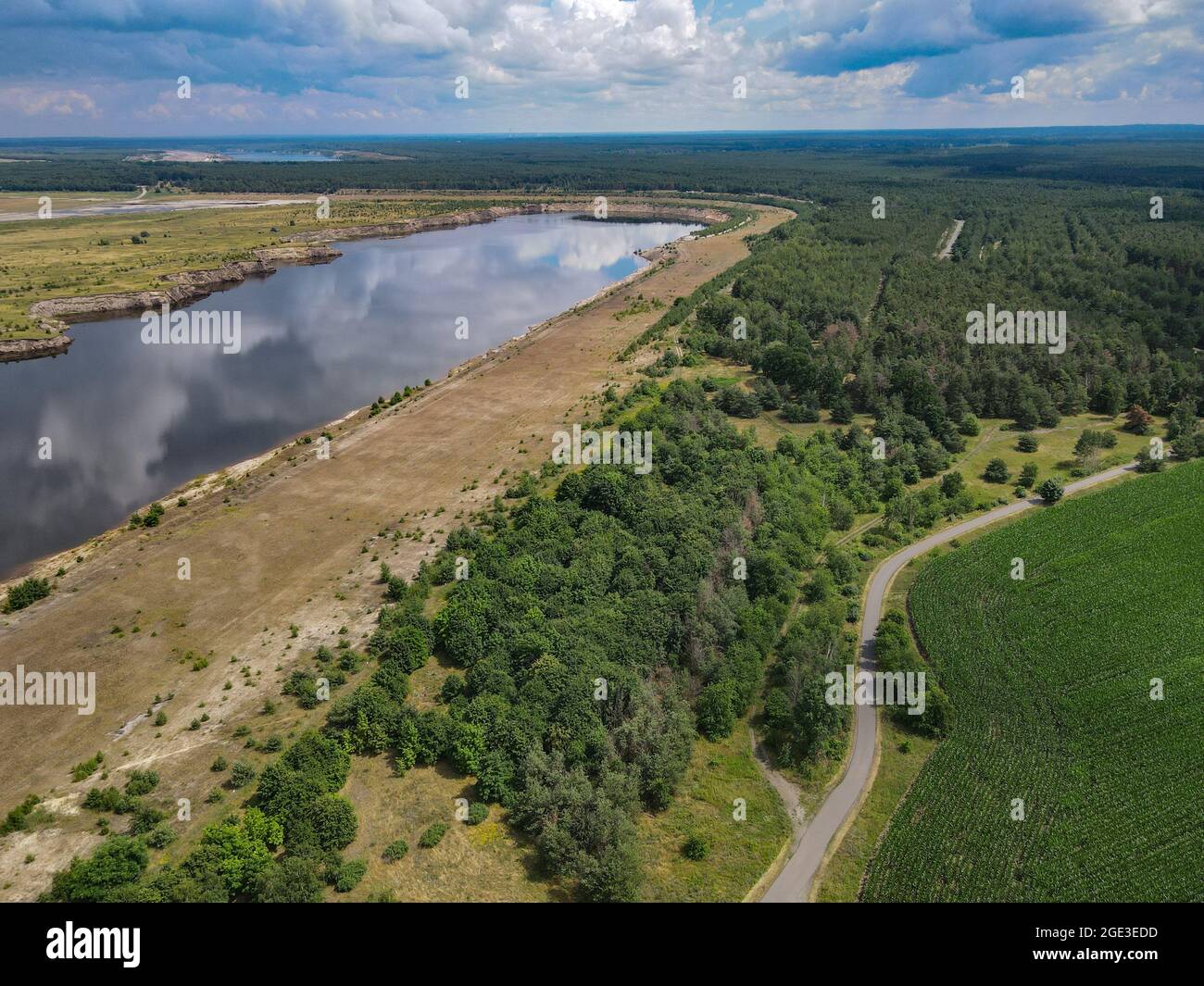 12 luglio 2021, Brandeburgo, Cottbus: Il bordo di una ex miniera di lignite a cielo aperto e futuro Cottbus Mar Baltico (vista aerea con un drone). Nel 1986, il villaggio di Klein Lieskow fu demolito qui vicino a causa dell'estrazione della lignite. Klein Lieskow era il 101esimo villaggio ad essere inghiottito dall'escavatore a carbone. In totale, 137 case nella zona mineraria di Lusazia sono scomparse nella miniera. La decisione di eliminare gradualmente il carbone entro il 2038 arriva troppo tardi per molti paesi. (Al dpa 'i luoghi visualizzati a Lusazia: 'C'è malinconia nella buca'') Foto: Patrick Pleul/dpa-Zentralbild/dpa Foto Stock