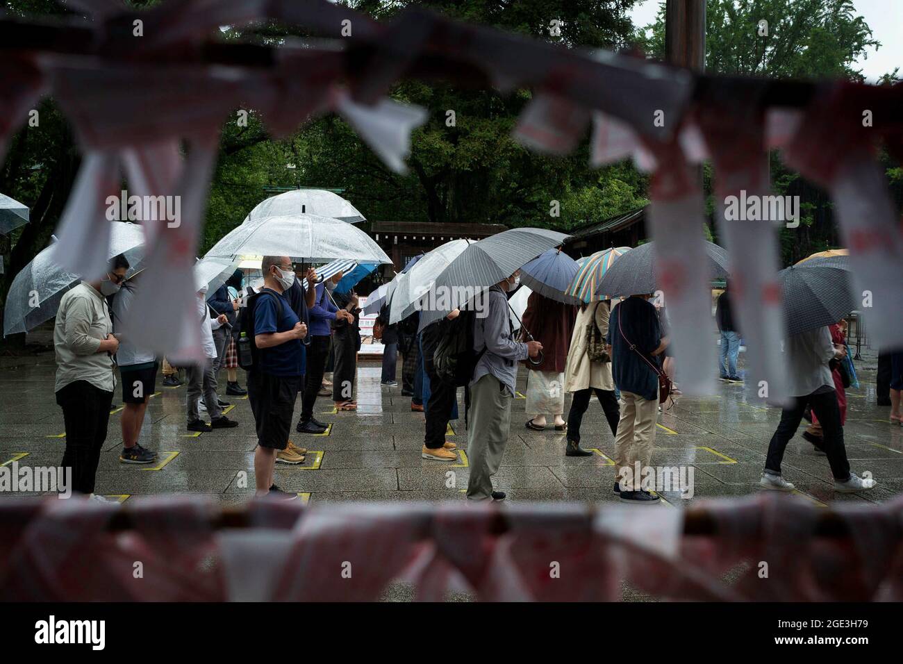 Nonostante la pioggia torrenziale, la gente rende omaggio durante la visita al Santuario di Yasukuni nel 76° anniversario della sconfitta della seconda guerra mondiale. Il 15 agosto in Giappone è l'anniversario della fine della guerra del Pacifico o della seconda guerra mondiale. Quest'anno è stato il 76° anno di questo ricordo al Santuario Yasukuni di Tokyo. Ogni anno, il 15 agosto, una folla diversa viene al santuario di Yasukuni per ricordare e rispettare i familiari e i cari che sono caduti vittime durante le guerre in Giappone, non solo la seconda guerra mondiale, ma tutte le guerre dal 1870 che sono state combattute al servizio dell'imperatore. Foto Stock