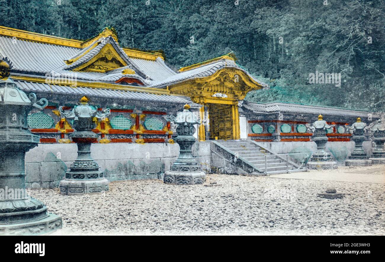 Vecchia cartolina giapponese colorata a mano di un santuario giapponese sconosciuto, con cancello d'ingresso principale e muro decorativo e lanterne in pietra all'esterno. Circa 1910. Foto Stock