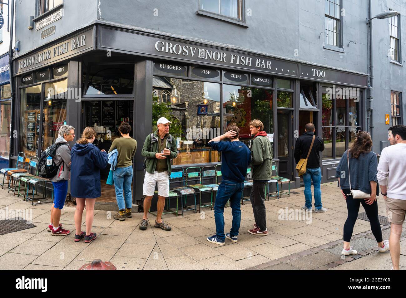 I clienti che aspettano all'esterno del famoso negozio di pesce e patatine Grosvenor nella Lower Goat Lane Norwich per l'ordine Foto Stock