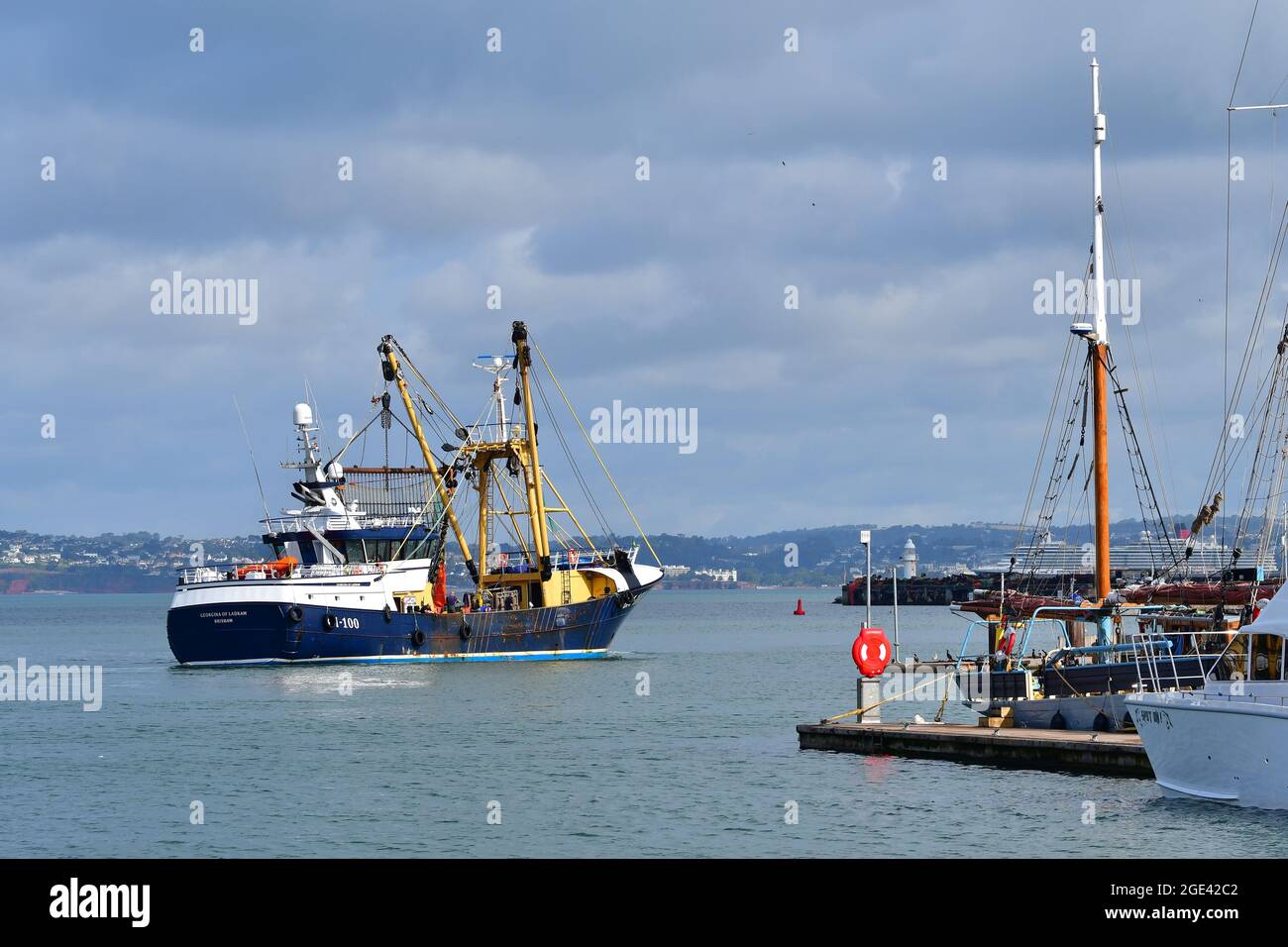In una mattinata mite in alta marea si vede un peschereccio da traino che lascia il porto di Brixham. Foto di Robert Timoney/AlamyStockPhoto Foto Stock