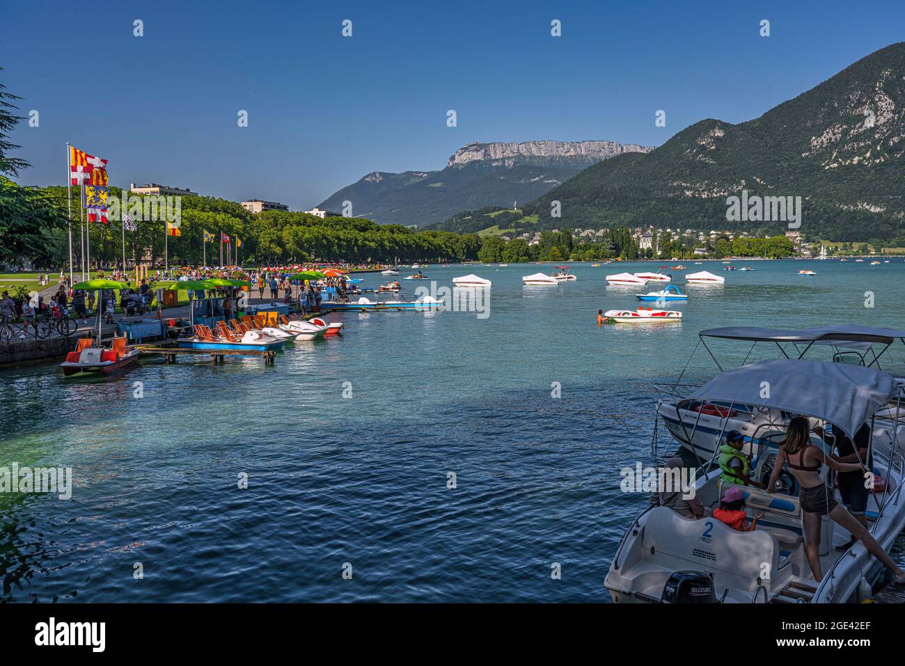 Divertimento estivo in una giornata estiva sul lago di Annecy. Turisti su pedalò e sotto ombrelloni. Annecy, dipartimento della Savoia, regione Auvergne-Rhône-Alpes, Francia Foto Stock