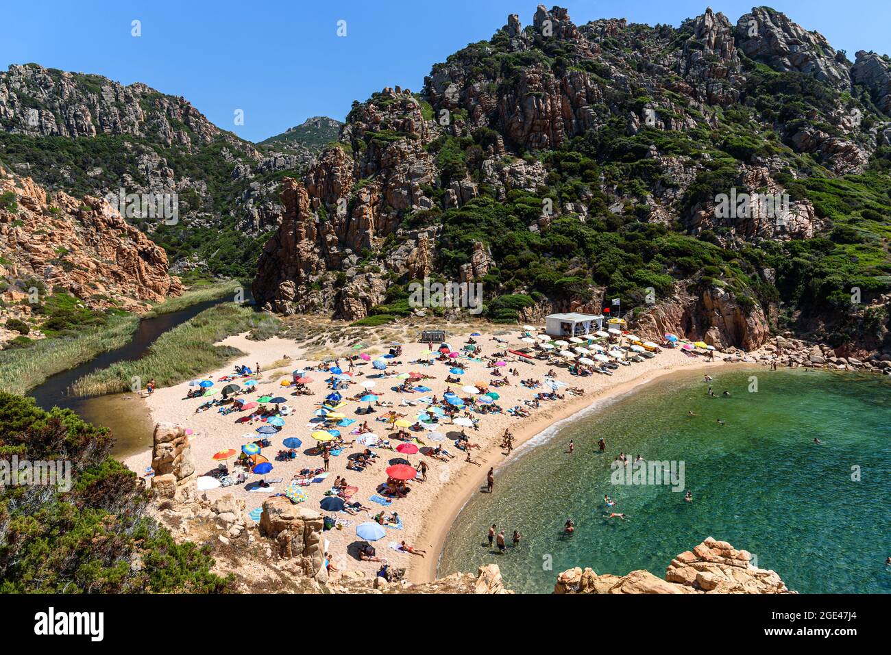Persone e ombrelloni / ombrelloni sulla spiaggia di li Cossi alla Costa Paradiso di Sardegna, Italia Foto Stock