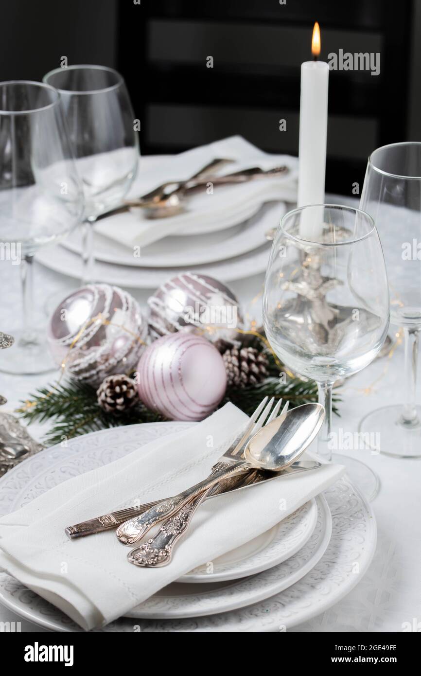 Tavolo natalizio con tovaglioli bianchi, posate a fettine antiche e portacandele Foto Stock