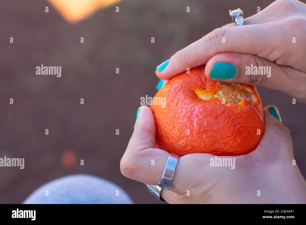 Mani femminili che pelano mandarino Foto Stock