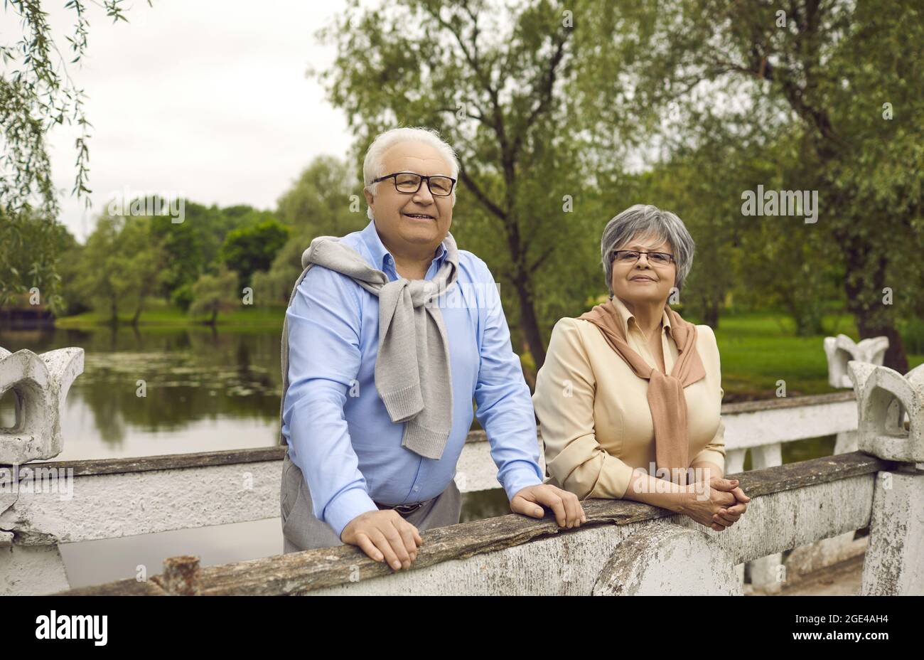 Ritratto di felice coppia in pensione rilassante in piedi sul ponte godere di riposo nel parco Foto Stock