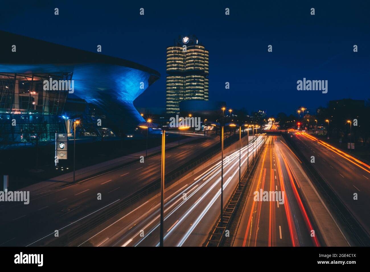 Lighttrails di strada trafficata di fronte alla sede centrale della BMW Foto Stock