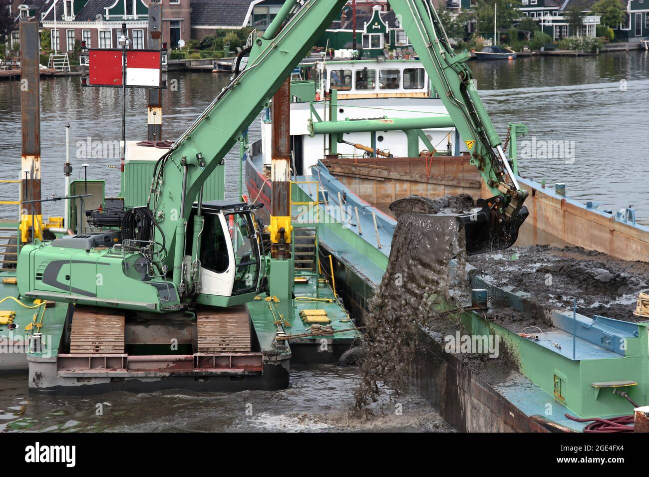 escavatore cingolato su pontile galleggiante che approfondisce il fairway su un fiume Foto Stock