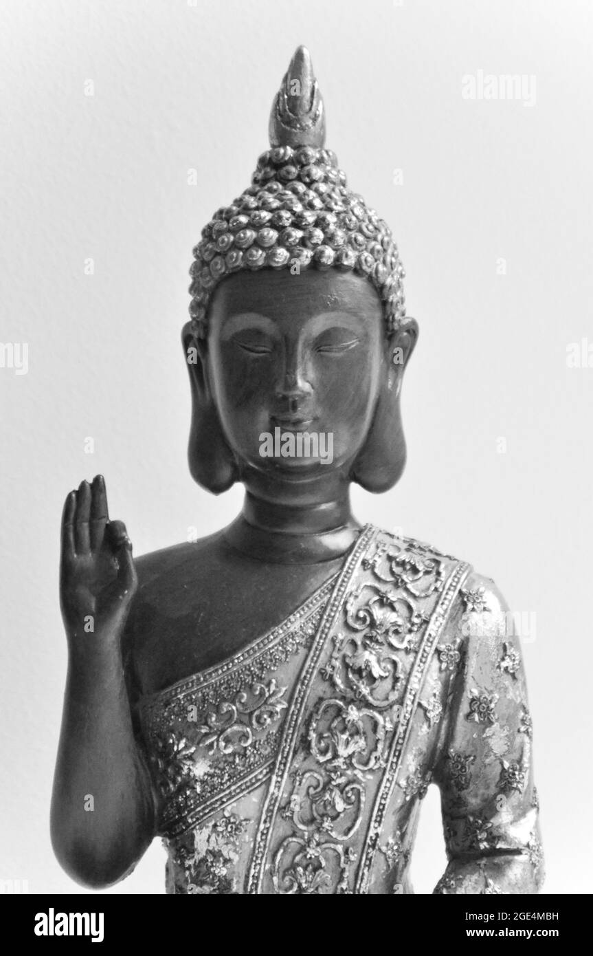 Immagine superiore del corpo e del viso di una statua di Buddha posta su sfondo bianco. L'immagine è in bianco e nero Foto Stock