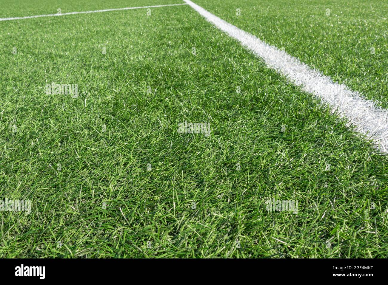 Calcio di fondo. Campo da calcio verde sintetico in erba artificiale con  linea a strisce bianche Foto stock - Alamy