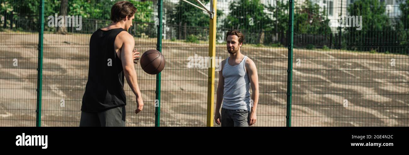 Uomini che giocano a basket sul campo, banner Foto Stock