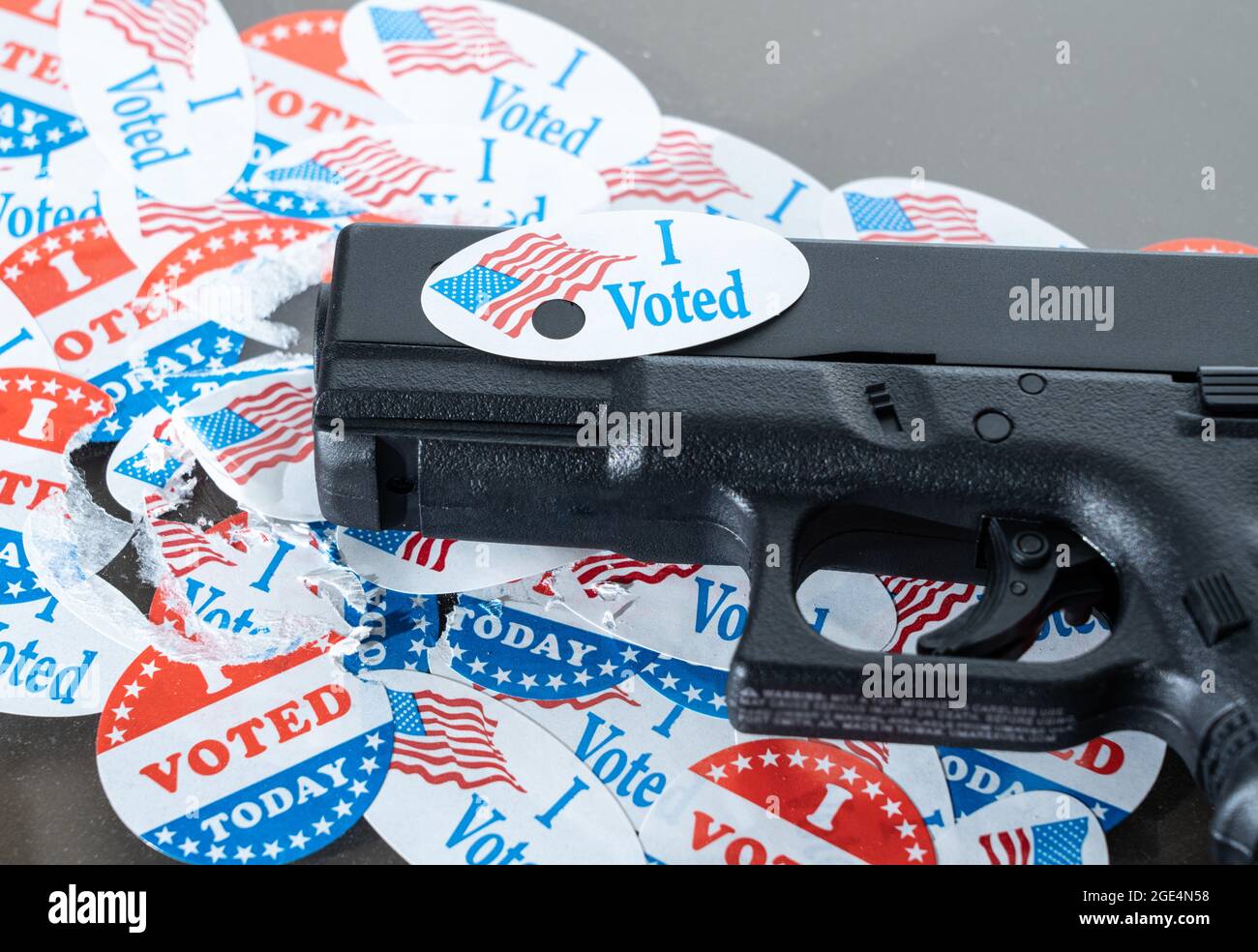 Concetto per la violenza elettorale con pistola decorata con ho votato oggi adesivo con buco fatto da proiettile sparato Foto Stock