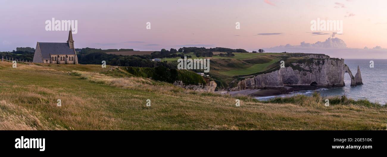 Étretat è meglio conosciuta per le sue scogliere di gesso, tra cui tre archi naturali e una formazione appuntita chiamata Aiguille o l'ago Foto Stock