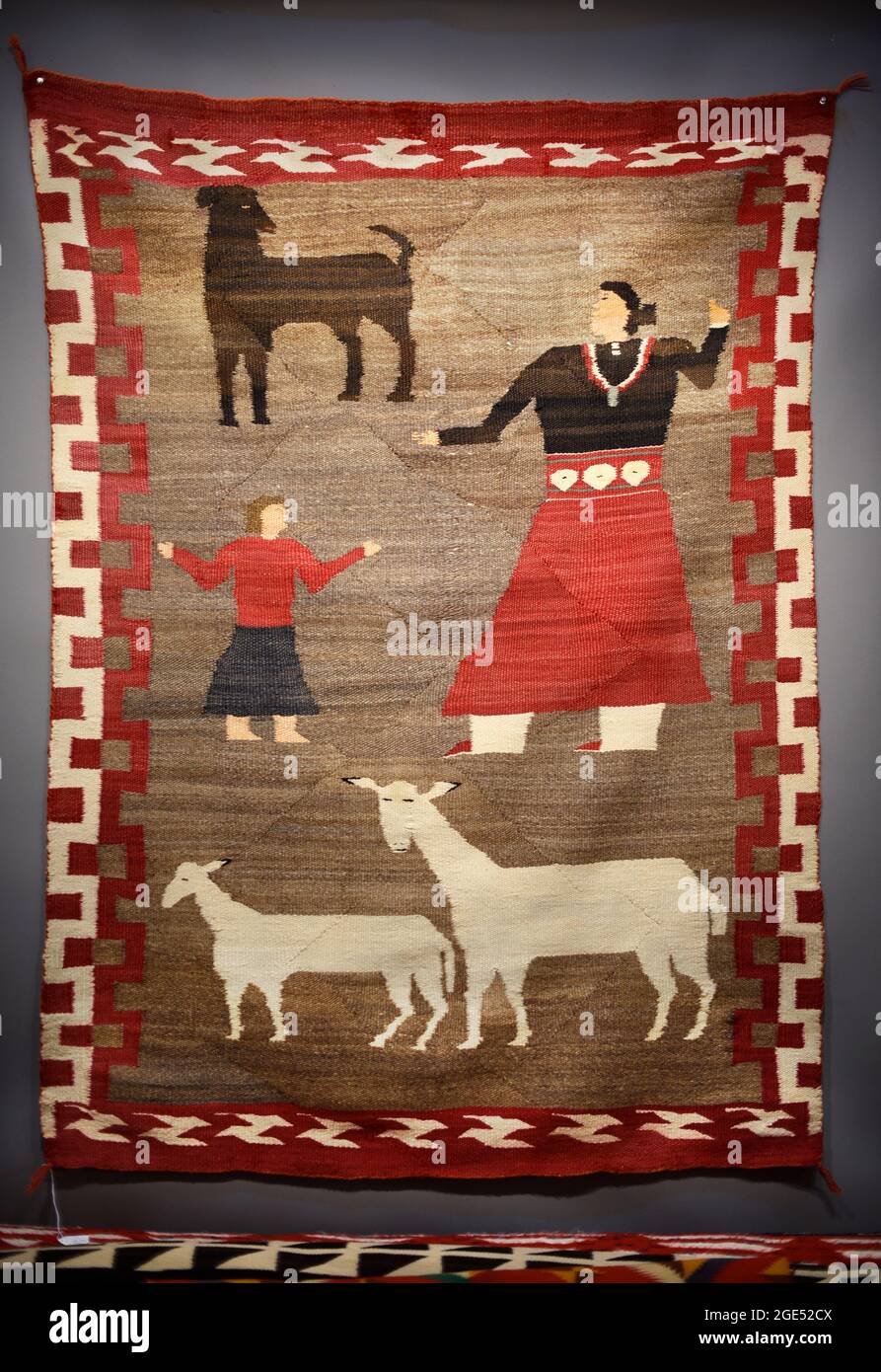 Una coperta di lana artigianale d'epoca prodotta da un tessitore Navajo in vendita a Santa Fe, NM, raffigura una madre e una figlia con pecore e una capra. Foto Stock