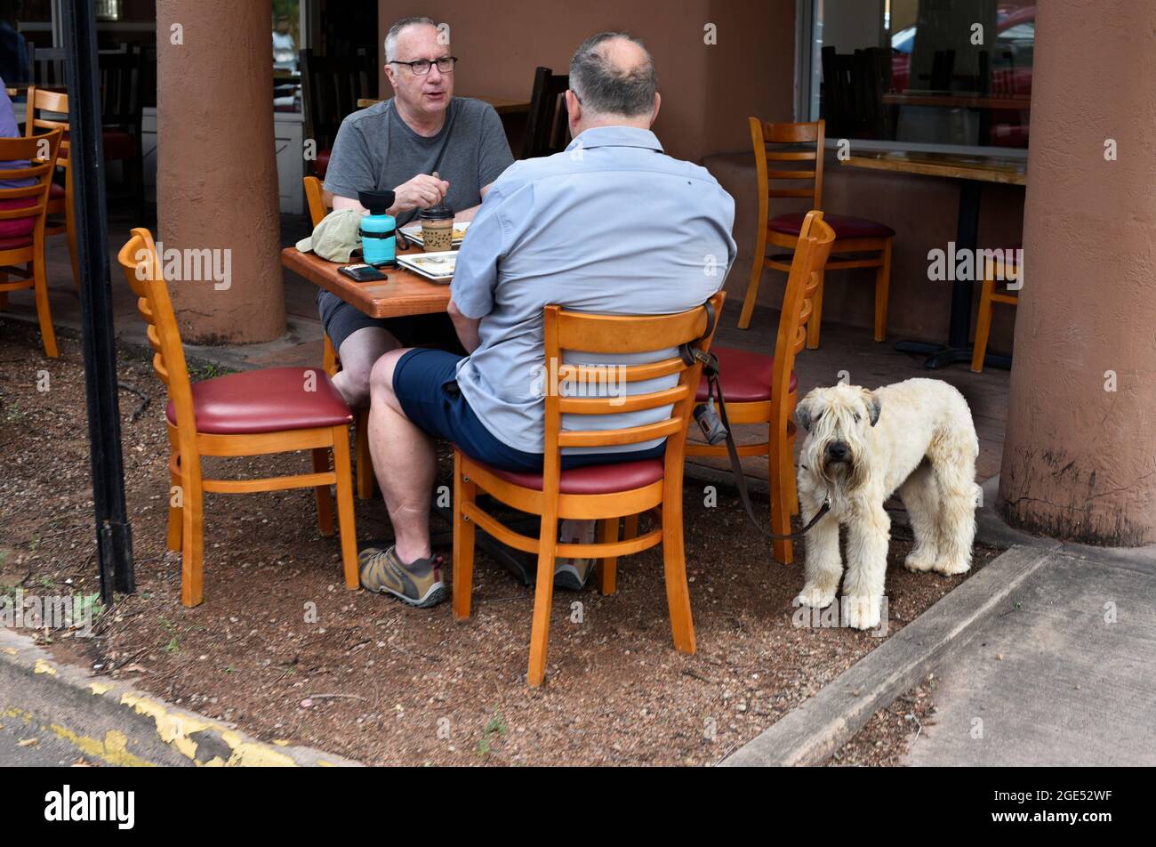 Due uomini si gustano il pranzo presso i tavoli all'aperto di un ristorante a Santa Fe, New Mexico. Foto Stock