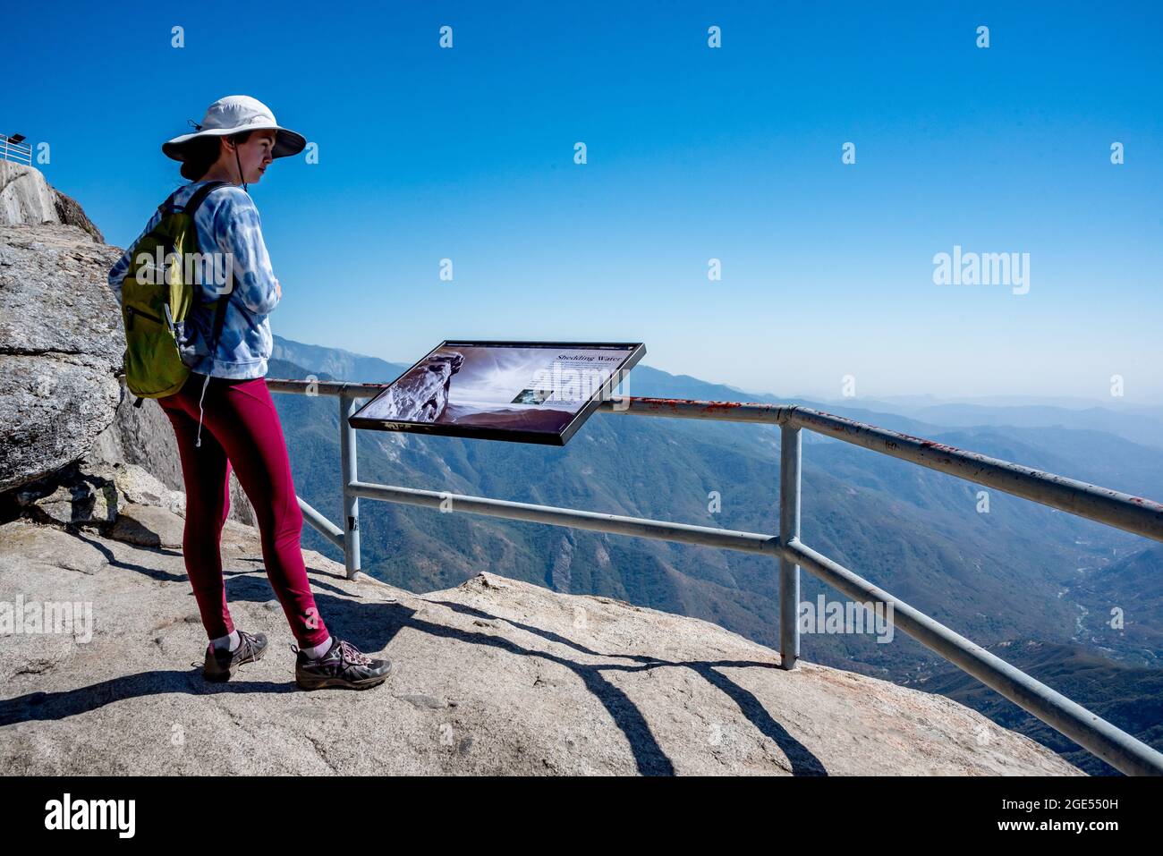 Una giovane donna si ferma a guardare fuori sopra il bivio medio del Kaweah River Canyon dove viaggia attraverso la foresta critica verso la valle di San Joaquin Foto Stock