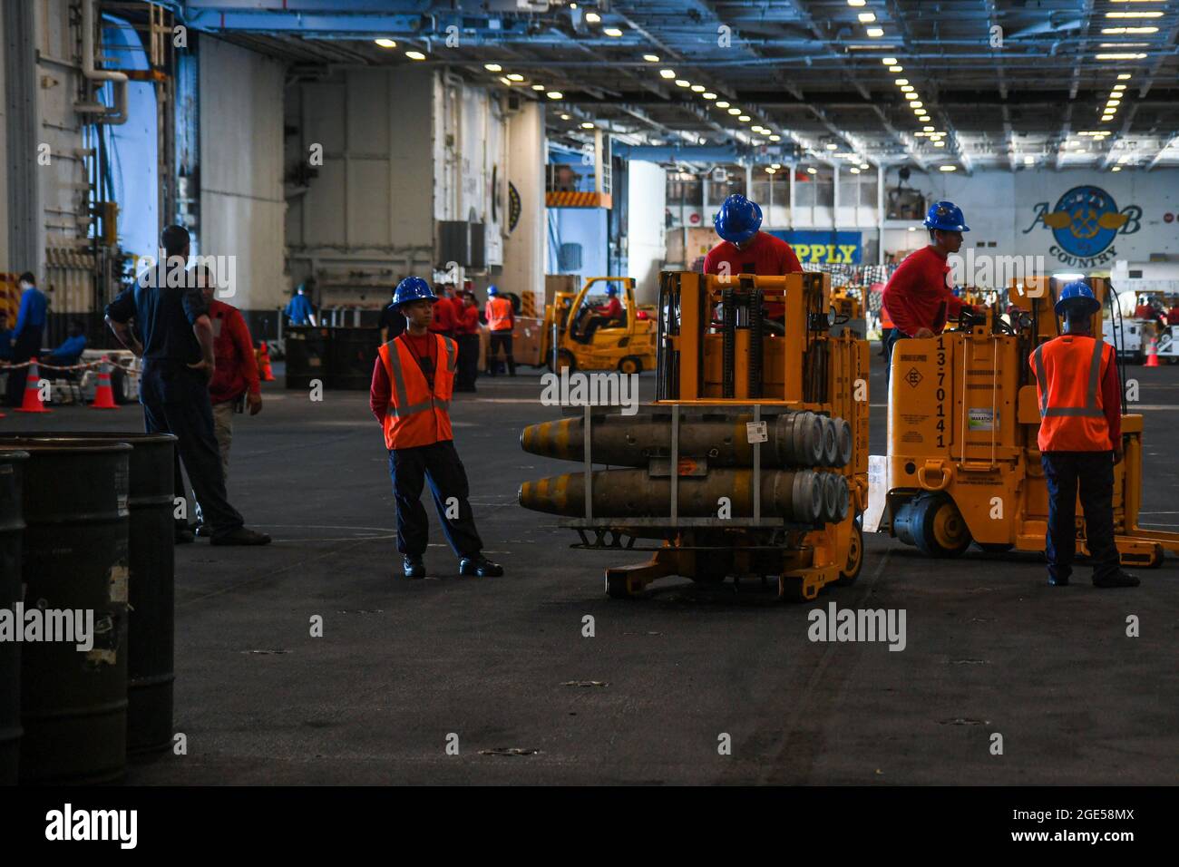 210813-N-MQ631-1050 OCEANO ATLANTICO (AGOSTO 13, 2021) marinai trasportano ordnance nella baia di hangar della portaerei di classe Nimitz USS Harry S. Truman (CVN 75). Truman sta conducendo un addestramento di preparazione nell'Oceano Atlantico in preparazione per le operazioni future. (STATI UNITI Navy Photo by Mass Communication Specialist 3rd Class Maxwell Higgins) Foto Stock