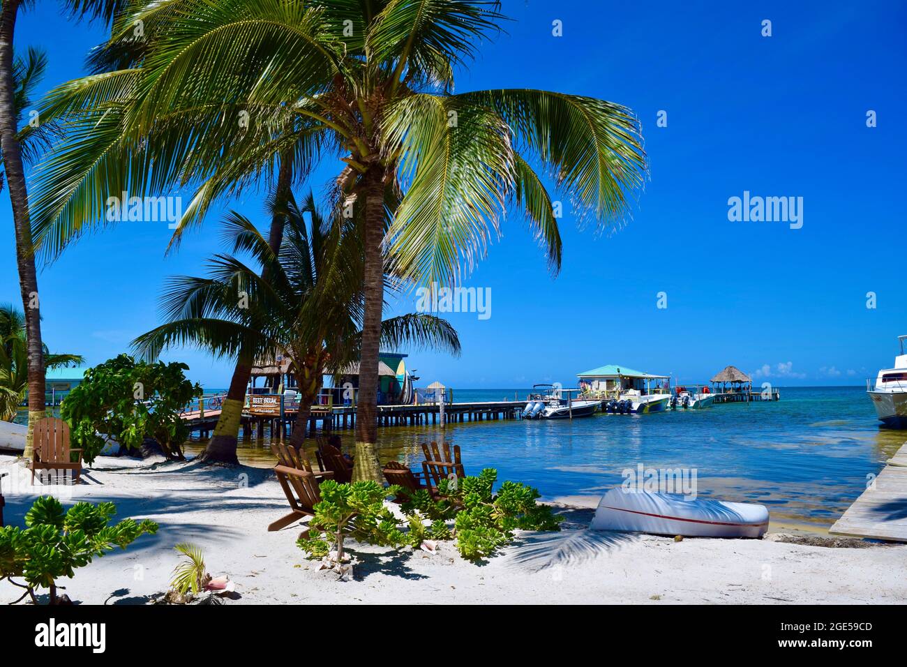 Una giornata luminosa e soleggiata con cielo blu chiaro e acqua calma e limpida su Caye Caulker, Belize Foto Stock