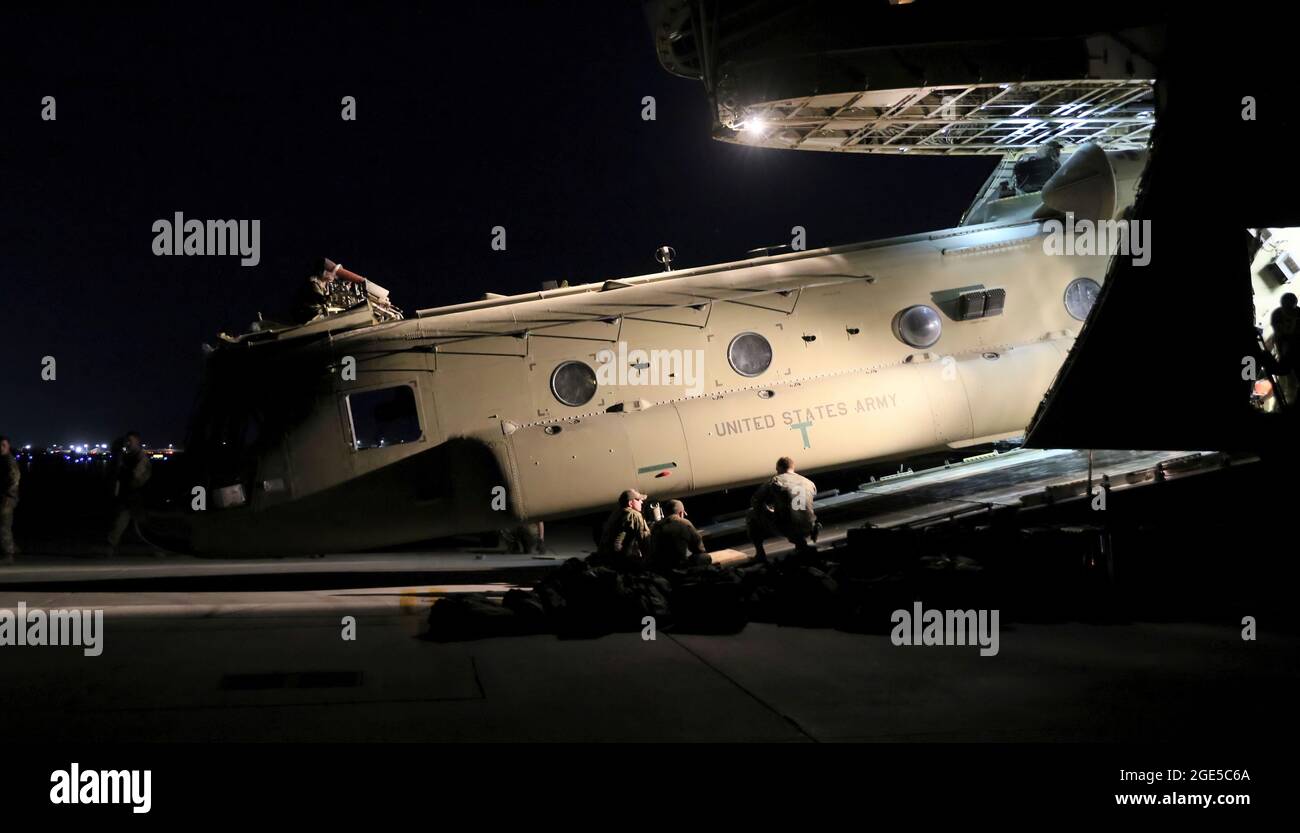 I portieri aerei lavorano con i manutentori per caricare un Chinook CH-47 in un Globemaster III C-17 a sostegno della missione di retrogrado Resolute Support in Afghanistan, 16 giugno 2021. (STATI UNITI Foto dell'esercito di Sgt. Corey Vandiver di prima classe) Foto Stock